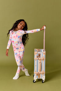 A Girl Wearing Serene Sunrise Long Sleeve Stretch Jersey Kids Pj Set with a bag