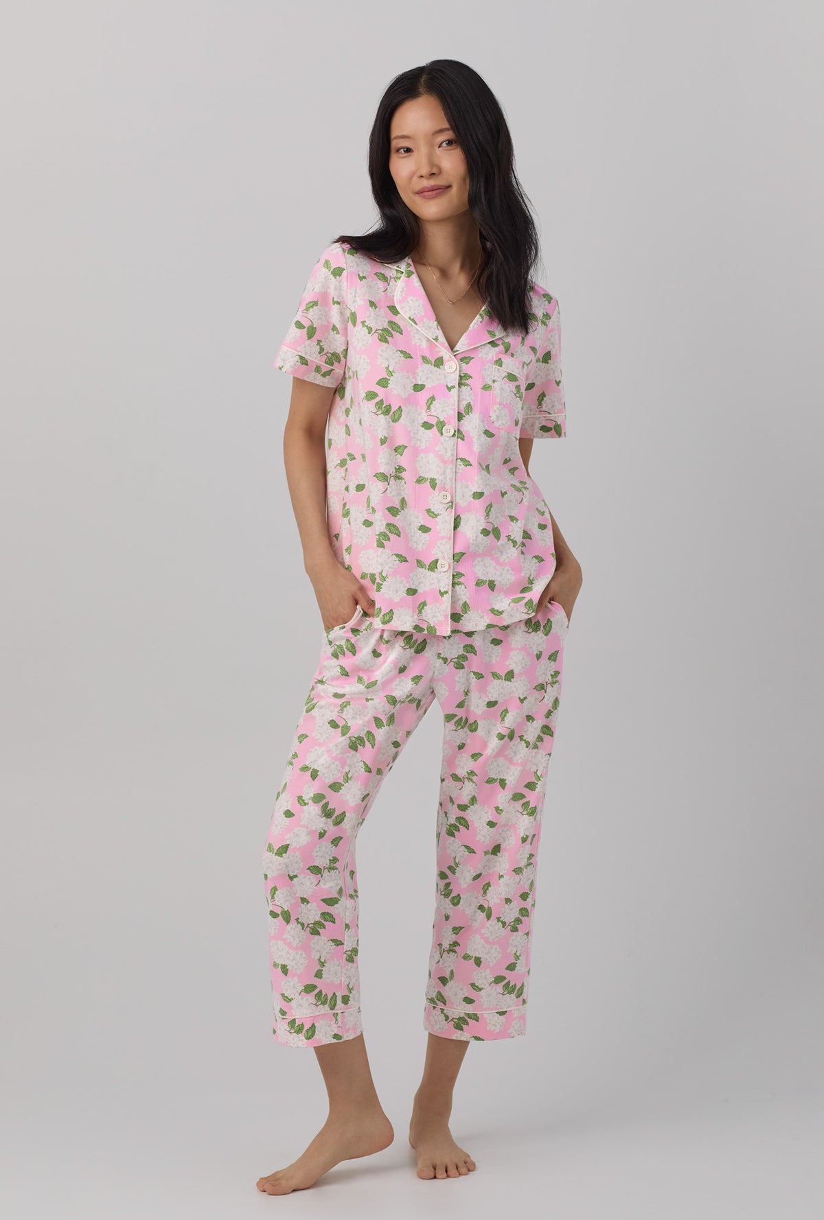 A lady wearing pink Hydrangea Short Sleeve Classic Stretch Jersey Cropped PJ Set with Pink Summer print.