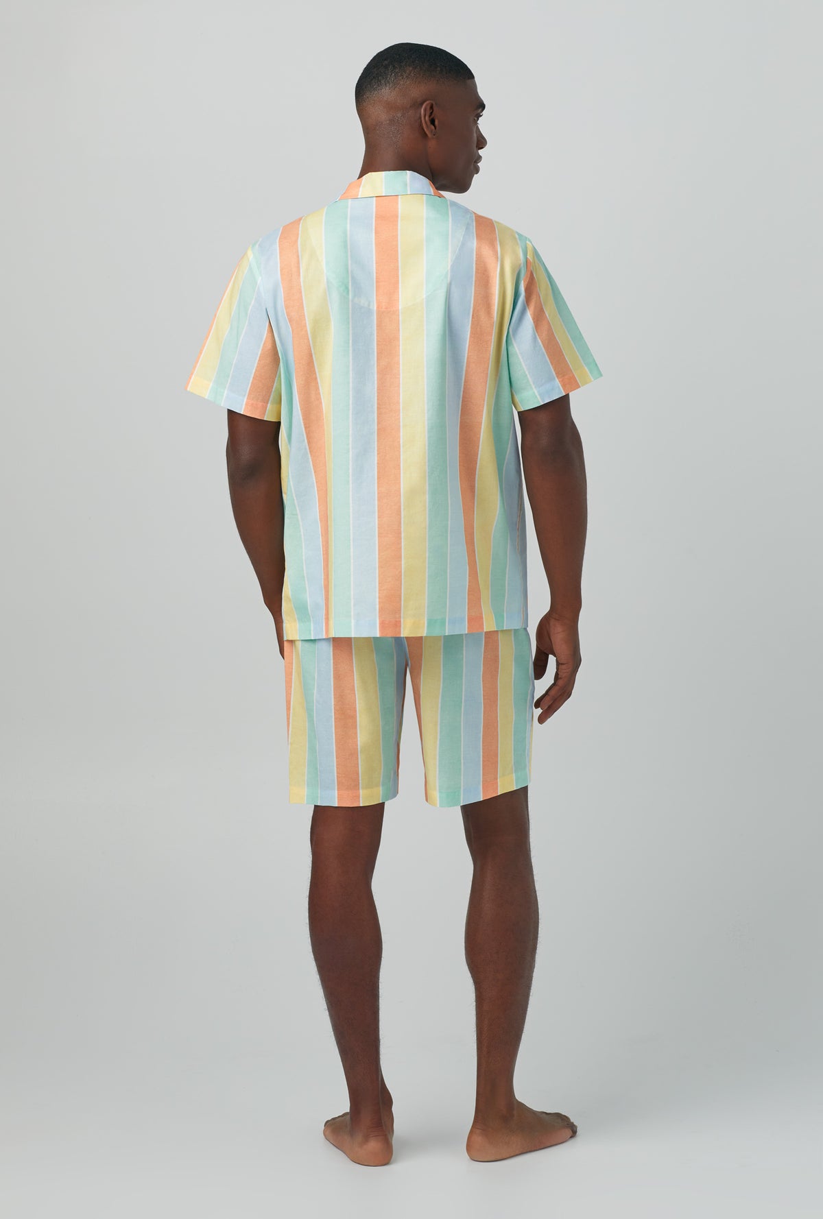 A man wearing multi color Short Sleeve Notch Woven Cotton Poplin Boxer PJ Set with Sunset Stripe print