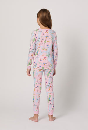 A girl wearing a pink pajama set with A print on a white background facing backwards