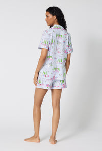 A Lady Wearing Belle Vie Short Sleeve Classic Shorty Stretch Jersey Pj Set facing to the side in a full standing pose