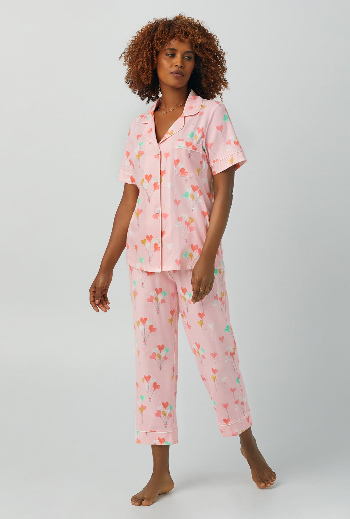 A lady wearing Short Sleeve Classic Stretch Jersey Cropped PJ Set with floating hearts print