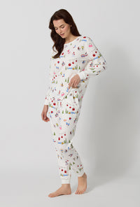 A lady wearing Snow Much Fun Long Sleeve Pullover Crew And Jogger Stretch Jersey Pj Set looking down