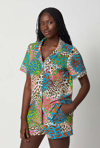 A lady wearing BedHead x Trina Turk Spray Leopard Short Sleeve Classic Shorty Stretch Jersey Pj Set