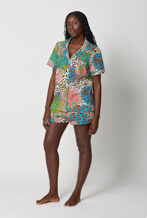 A lady wearing BedHead x Trina Turk Spray Leopard Short Sleeve Classic Shorty Stretch Jersey Pj Set