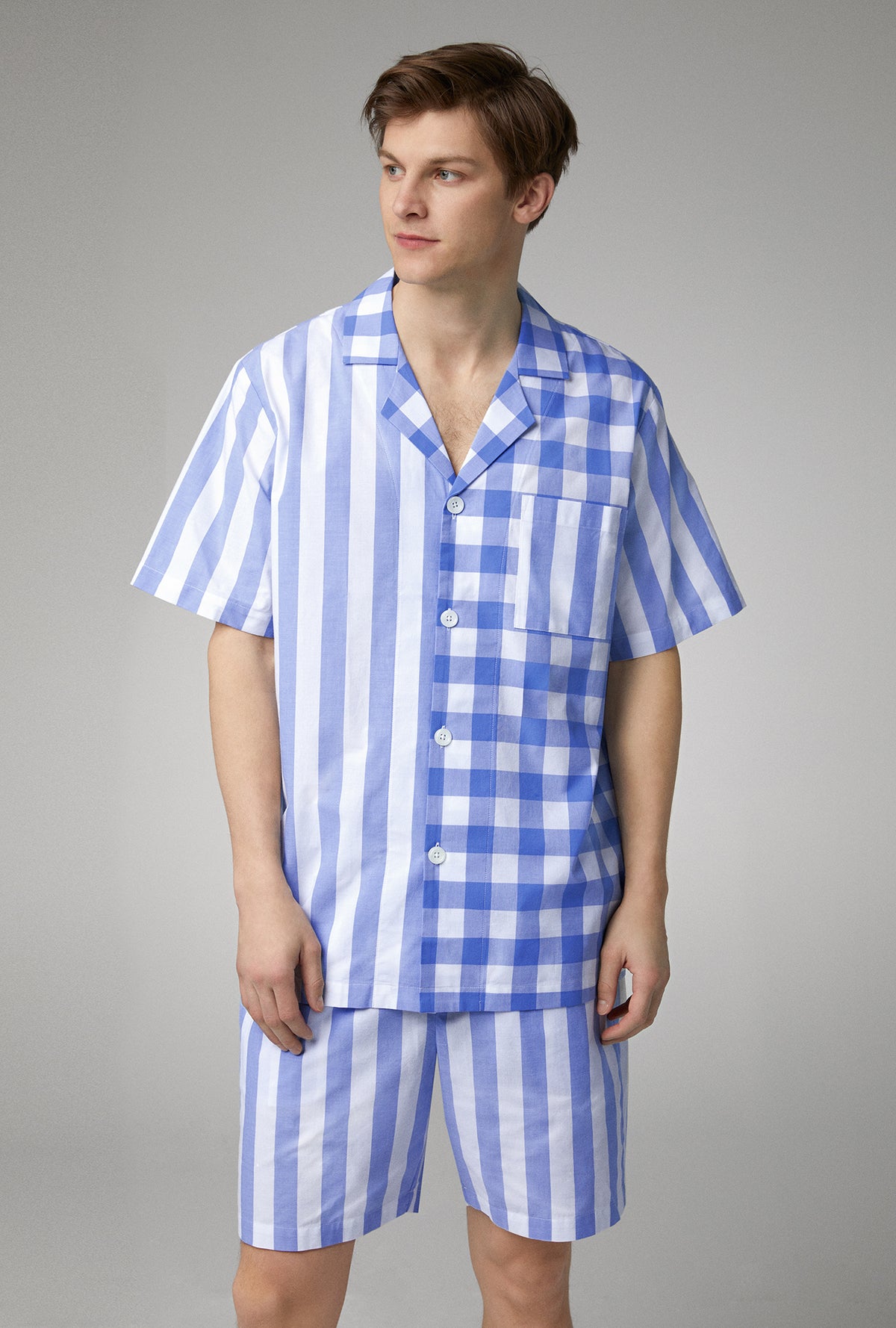 A man wearing blue men&#39;s short sleeve notch woven cotton poplin boxer pj set with bengal stripe.