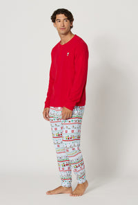 A man wearing Peanuts® Winter Parade Men's Long Sleeve Henley And Jogger Stretch Jersey Pj Set looking side