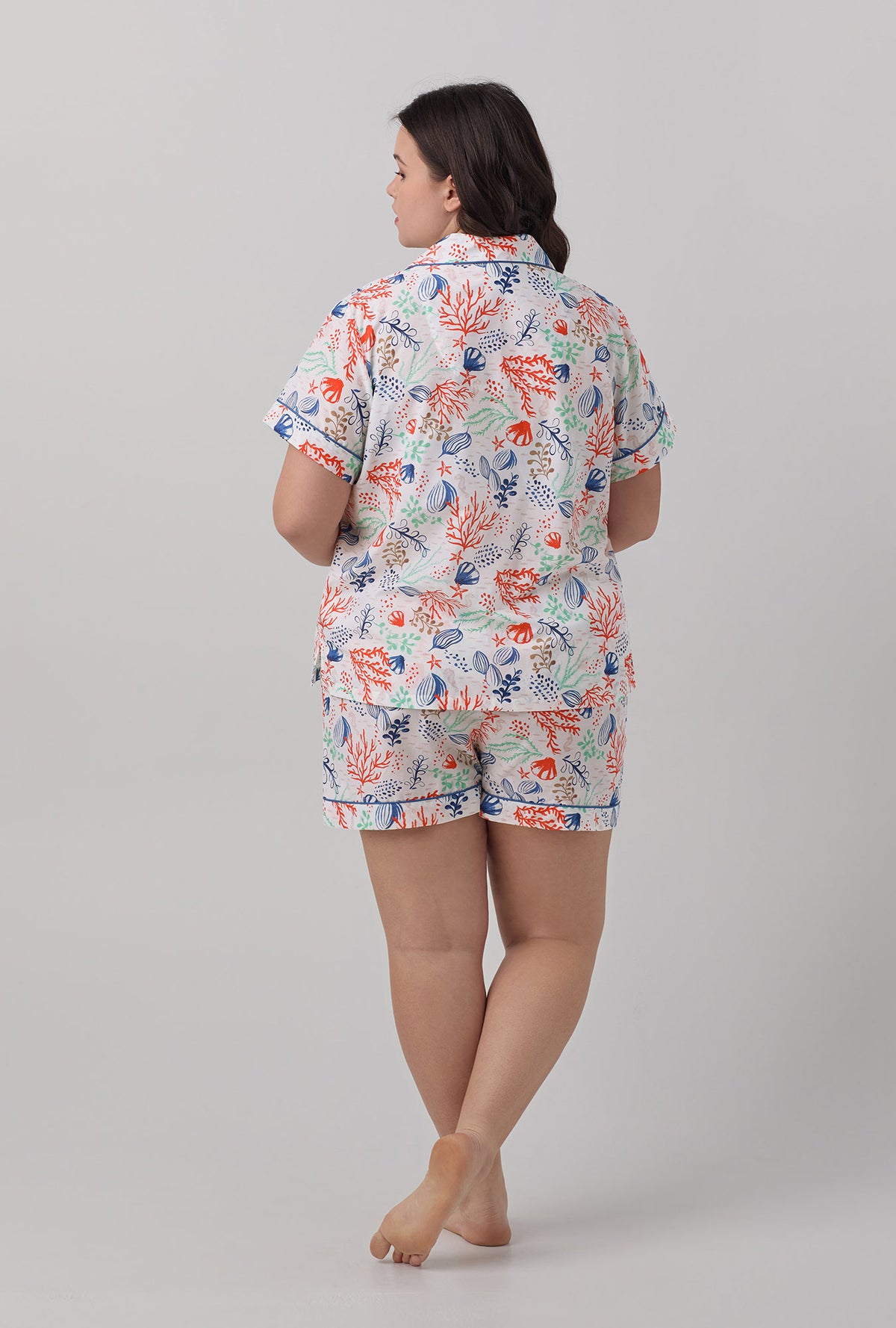 A lady wearing short sleeve classic plus size pj set with coral reef print.