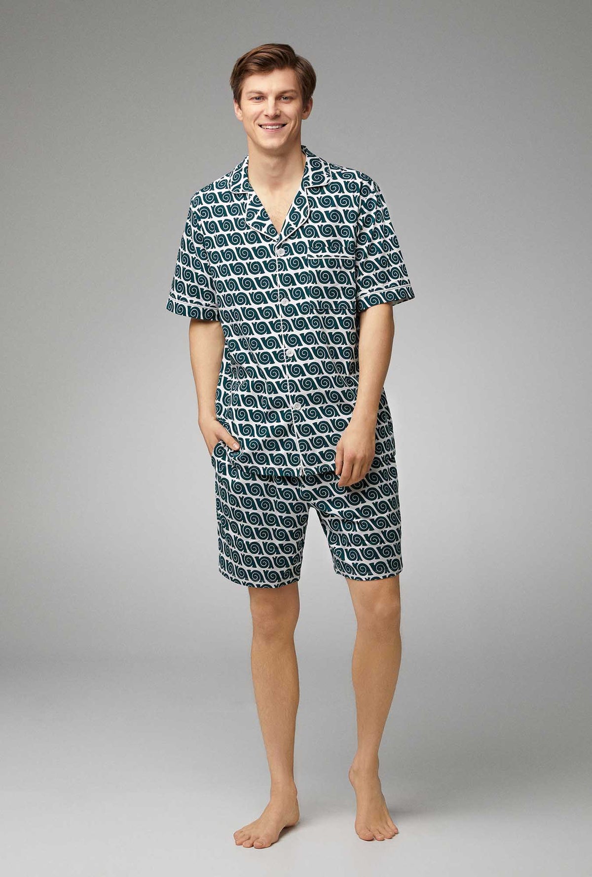 A man wearing teal and white short sleeve stretch jersey boxer pj set with snail print.
