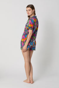 A lady wearing BedHead x Trina Turk Jungle Short Sleeve Classic Shorty Stretch Jersey Pj Set