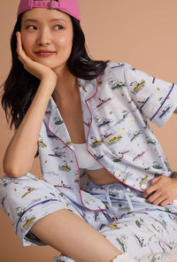 A lady wearing Catch A Wave Snoopy Short Sleeve Classic Woven Cotton Poplin Cropped Pj Set sitting down