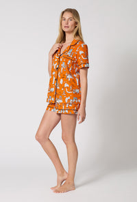 A Lady Wearing Orange Spooky In The City Short Sleeve Classic Shorty Stretch Jersey Pj Set in a side angled pose