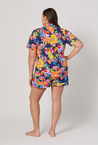 A lady wearing plus size BedHead x Trina Turk Bay Street Bloom Short Sleeve Classic Shorty Stretch Jersey Pj Set