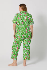 A Lady Wearing Plus Size Monstera Bloom Short Sleeve Classic Stretch Jersey Cropped Pj Set posing with a back view