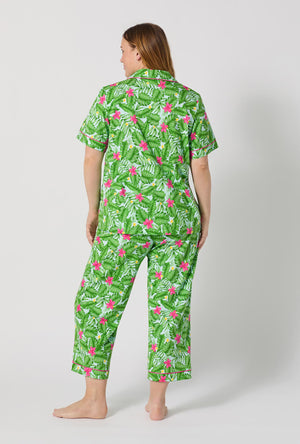A Lady Wearing Plus Size Monstera Bloom Short Sleeve Classic Stretch Jersey Cropped Pj Set posing with a back view