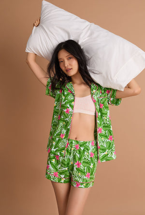 A Lady Wearing Monstera Bloom Short Sleeve Classic Shorty Stretch Jersey Pj Set Facing front in a stylish pose while holding a pillow