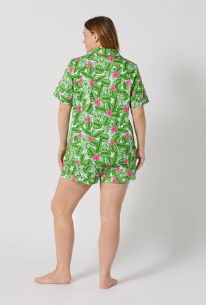 A Lady Wearing Plus Size Monstera Bloom Short Sleeve Classic Shorty Stretch Jersey Pj Set posing with a back view look