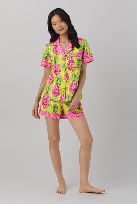 A lady wearing short sleeve classic shorty woven cotton poplin pj set with kiwi pineapple print