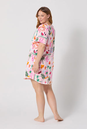 A Lady Wearing Plus Size Tropical Daydream Stretch Jersey T-shirt Sleep Dress posing back view while looking back over the shoulder