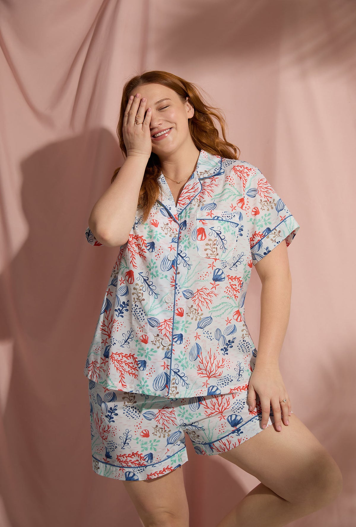 A lady wearing short sleeve classic plus size pj set with coral reef print.