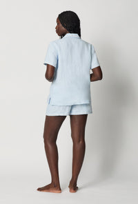 A lady wearing Baby's Breath Blue Short Sleeve Classic Shorty Woven Linen Pj Set back view