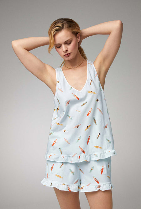A lady wearing white ruffle tank shorty stretch jersey pj set with retro surf print.
