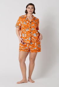 A Lady Wearing Plus Size Orange Spooky In The City Short Sleeve Classic Shorty Stretch Jersey Pj Set