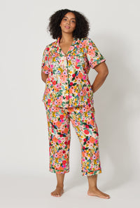 A lady wearing plus size Rifle Paper Co. x BedHead PJs Garden Party Short Sleeve Classic Stretch Jersey Cropped Pj Set
