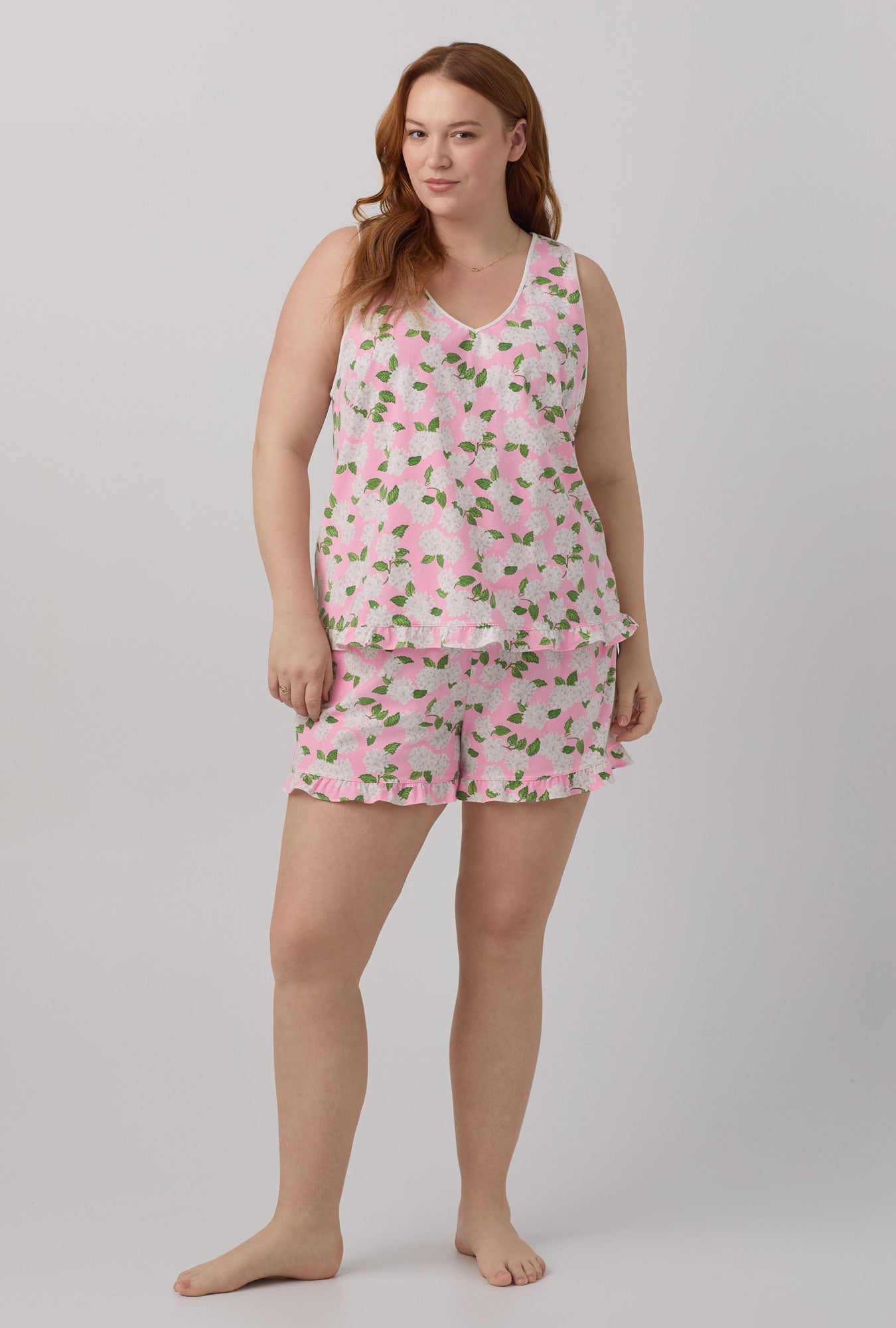 A lady wearing pink Ruffle Tank Shorty Stretch Jersey PJ Set with Pink Summer Hydrangea print.