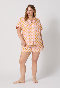 A Lady Wearing Plus Size Deco Sunset Short Sleeve Classic Woven Cotton Poplin Shorty Pj Set posing with a front view look