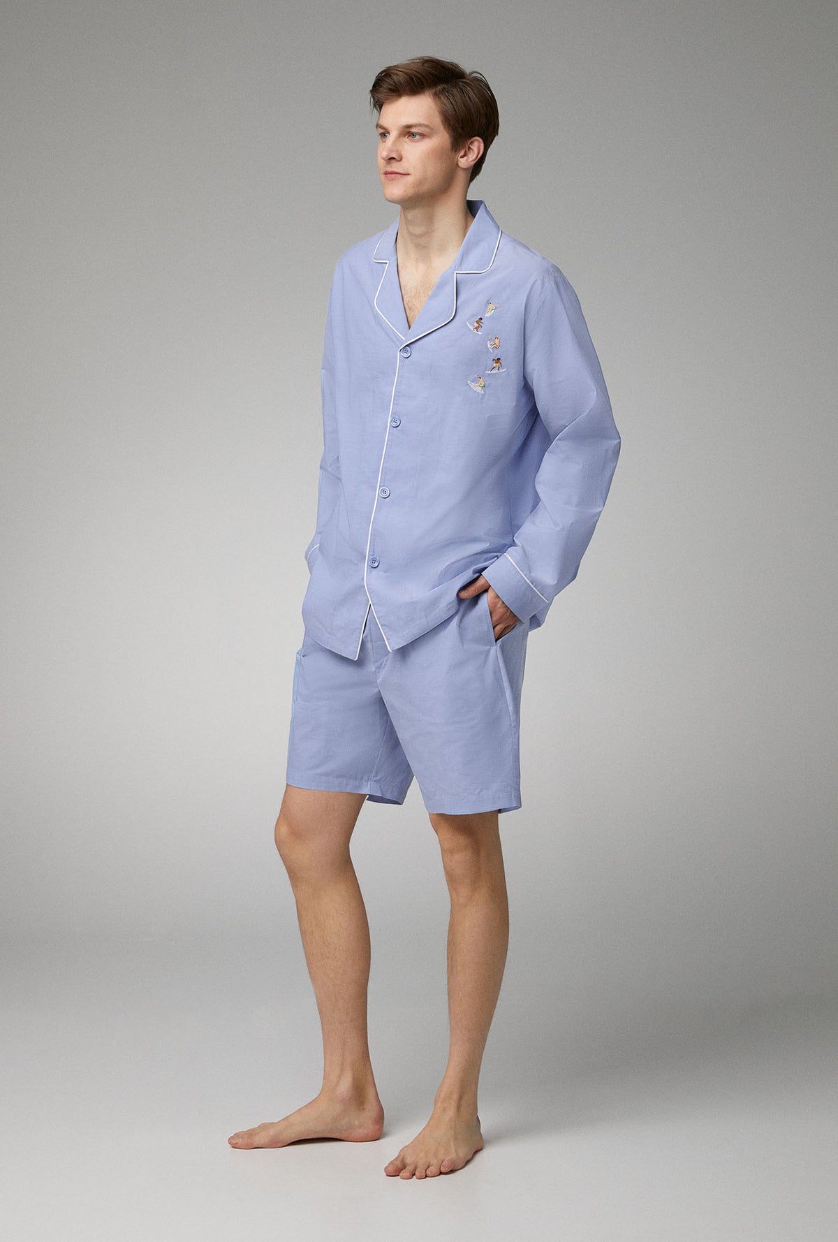 A man wearing blue long sleeve woven cotton poplin boxer short pj set with chambray print.