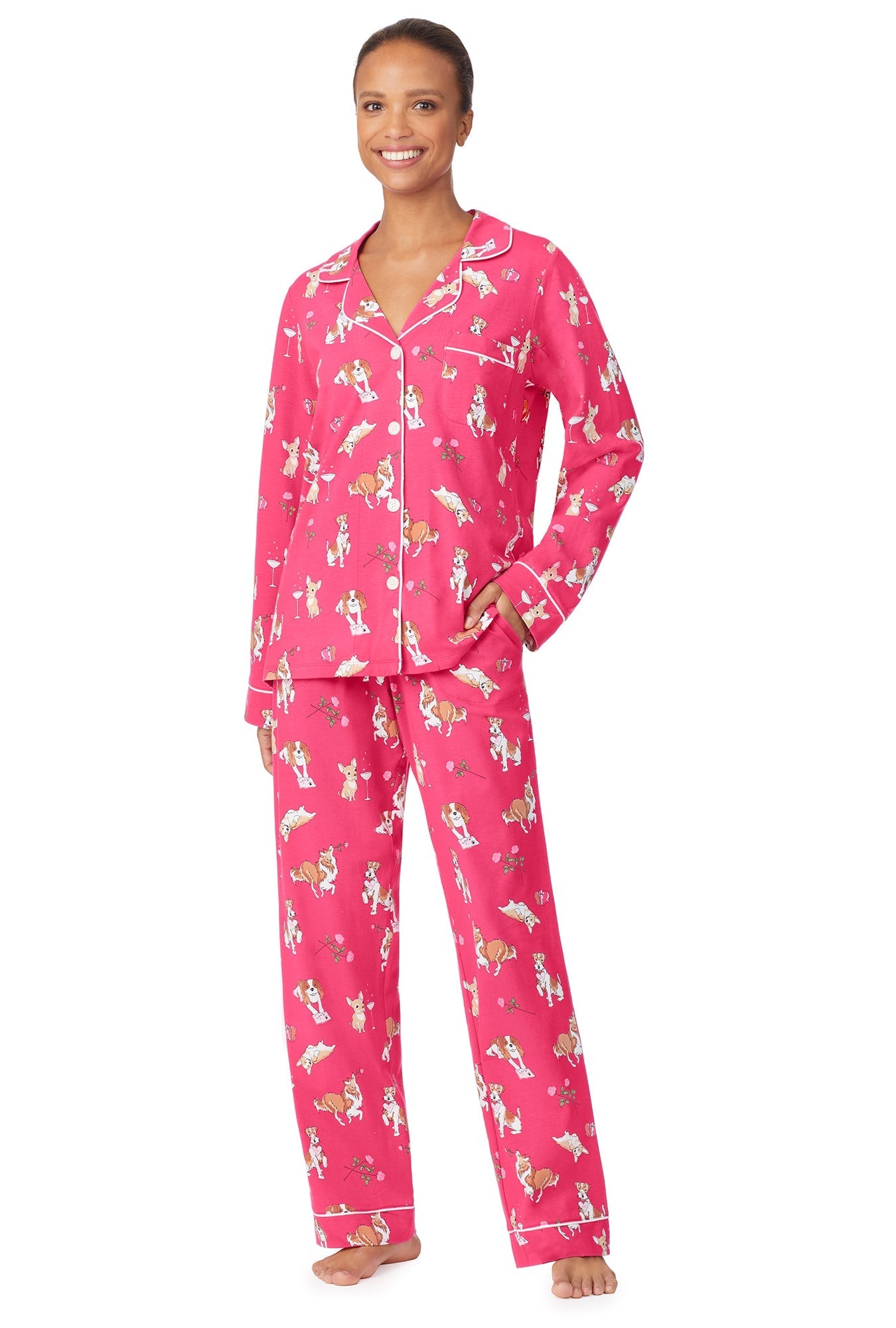 A lady wearing a pink long sleeve pj set with cheering pets pattern.