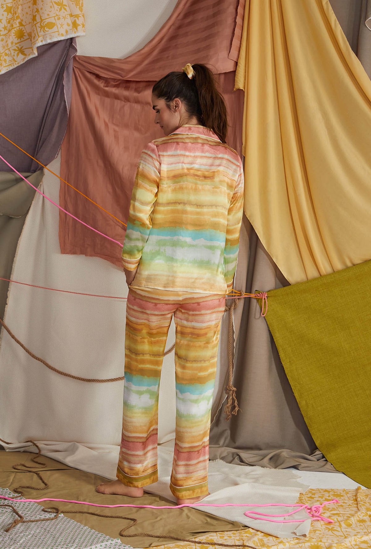 A lady wearing multi color long sleeve classic woven washable silk pj set with island sunset print.