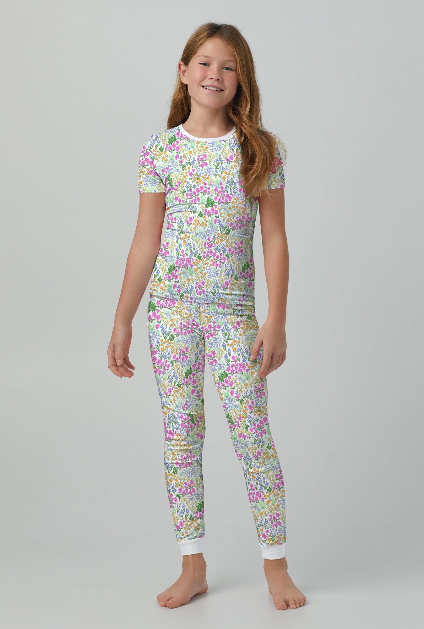 A kid wearing multi color short sleeve stretch jersey kids pj set with cottage garden print.