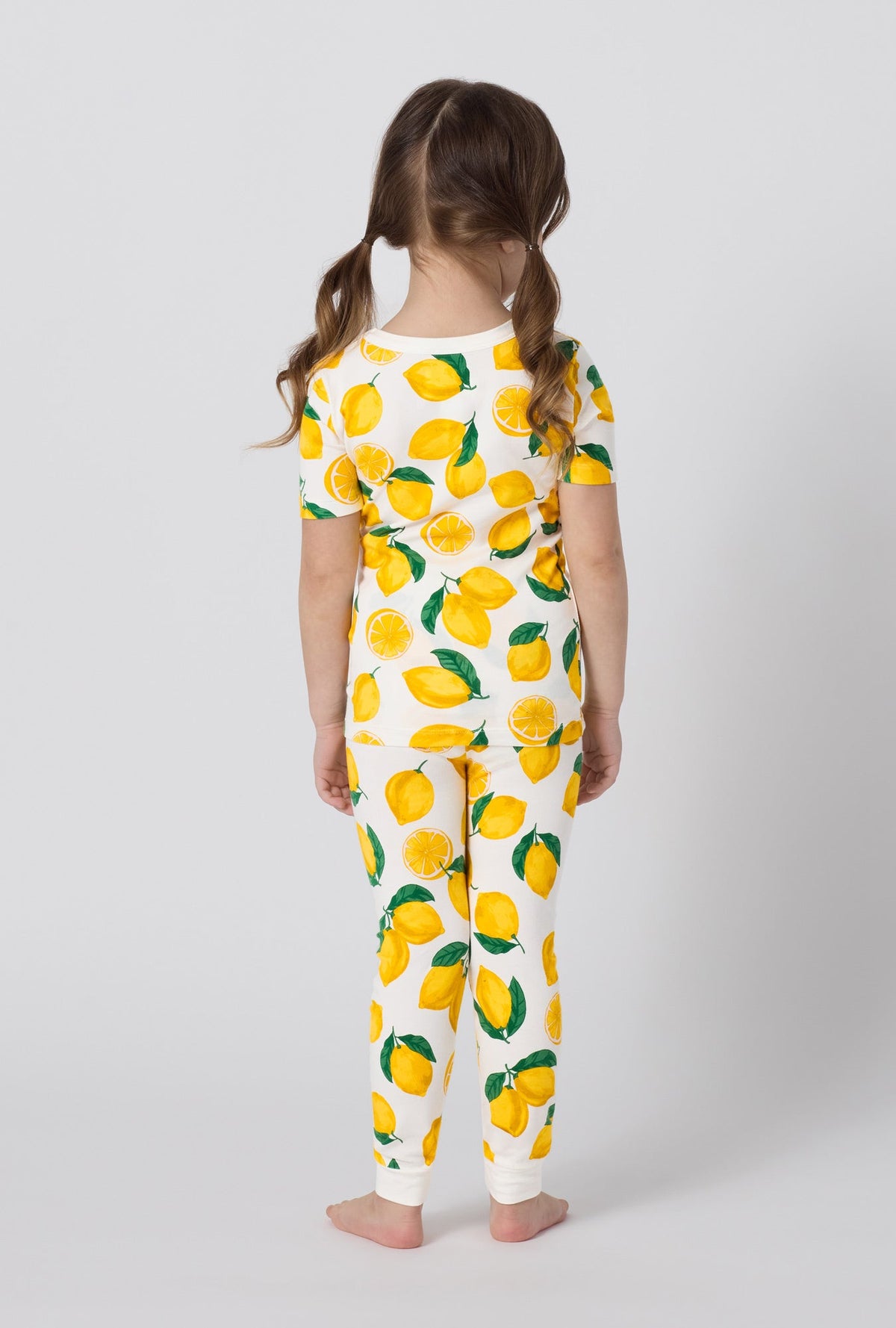 A girl wearing White and  Yellow Short Sleeve Stretch Jersey Kids Pj Set back view