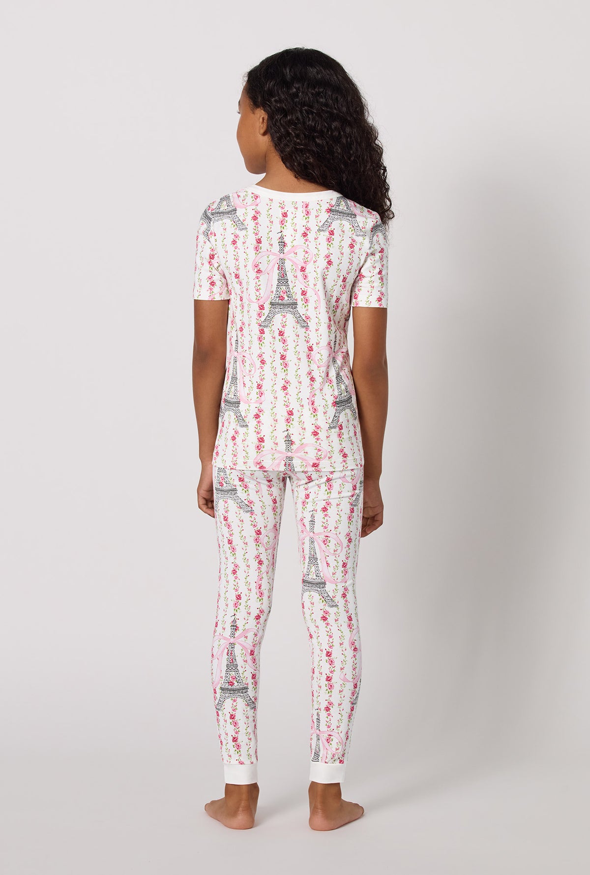 A Girl Wearing Fleur De La Tour Short Sleeve Stretch Jersey Kids Pj Set in a back view pose
