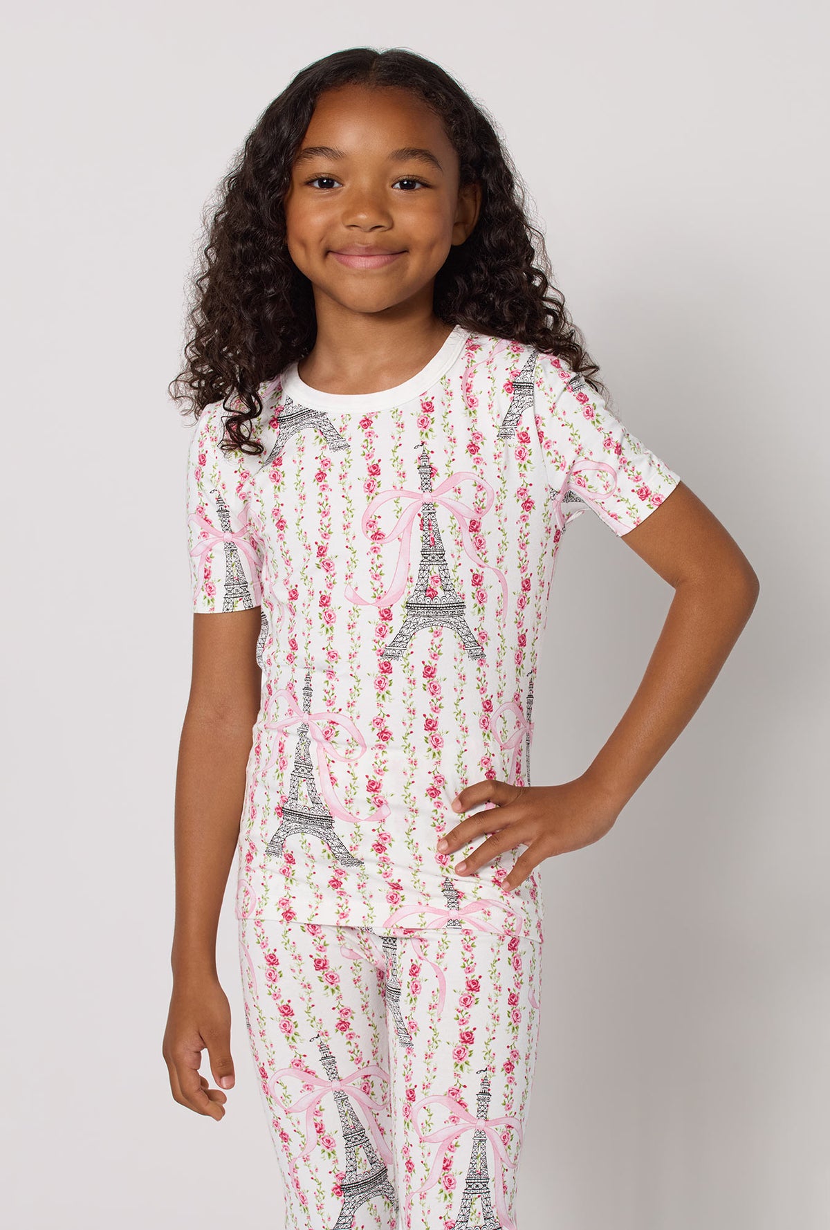 A Girl Wearing Fleur De La Tour Short Sleeve Stretch Jersey Kids Pj Set in a half close up shot