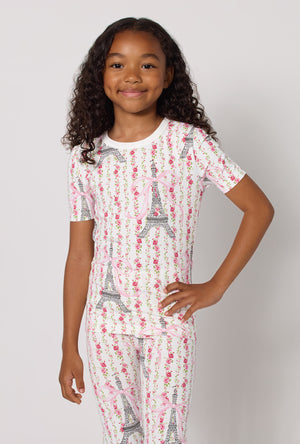 A Girl Wearing Fleur De La Tour Short Sleeve Stretch Jersey Kids Pj Set in a half close up shot