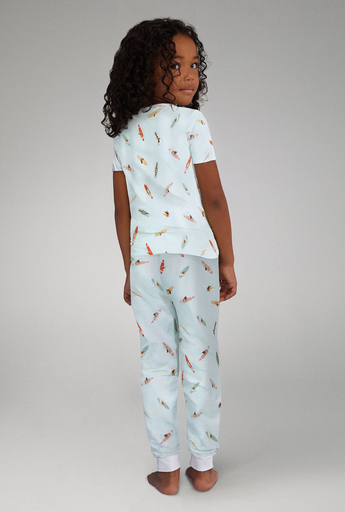 A girl wearing white short sleeve stretch jersey pj set with retro surf print.