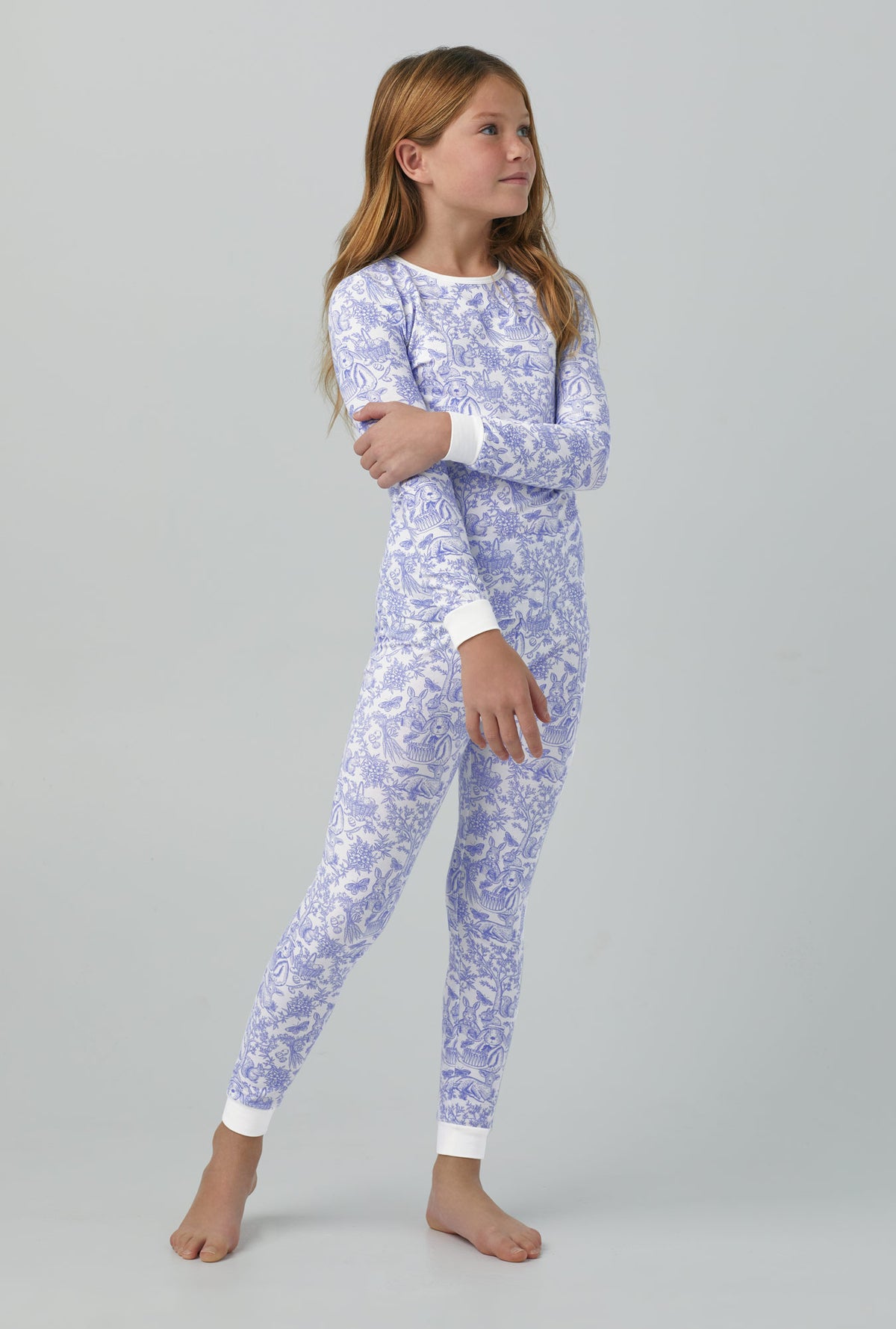A girl wearing Long Sleeve Stretch Jersey Kids PJ Set with fairytale forest print
