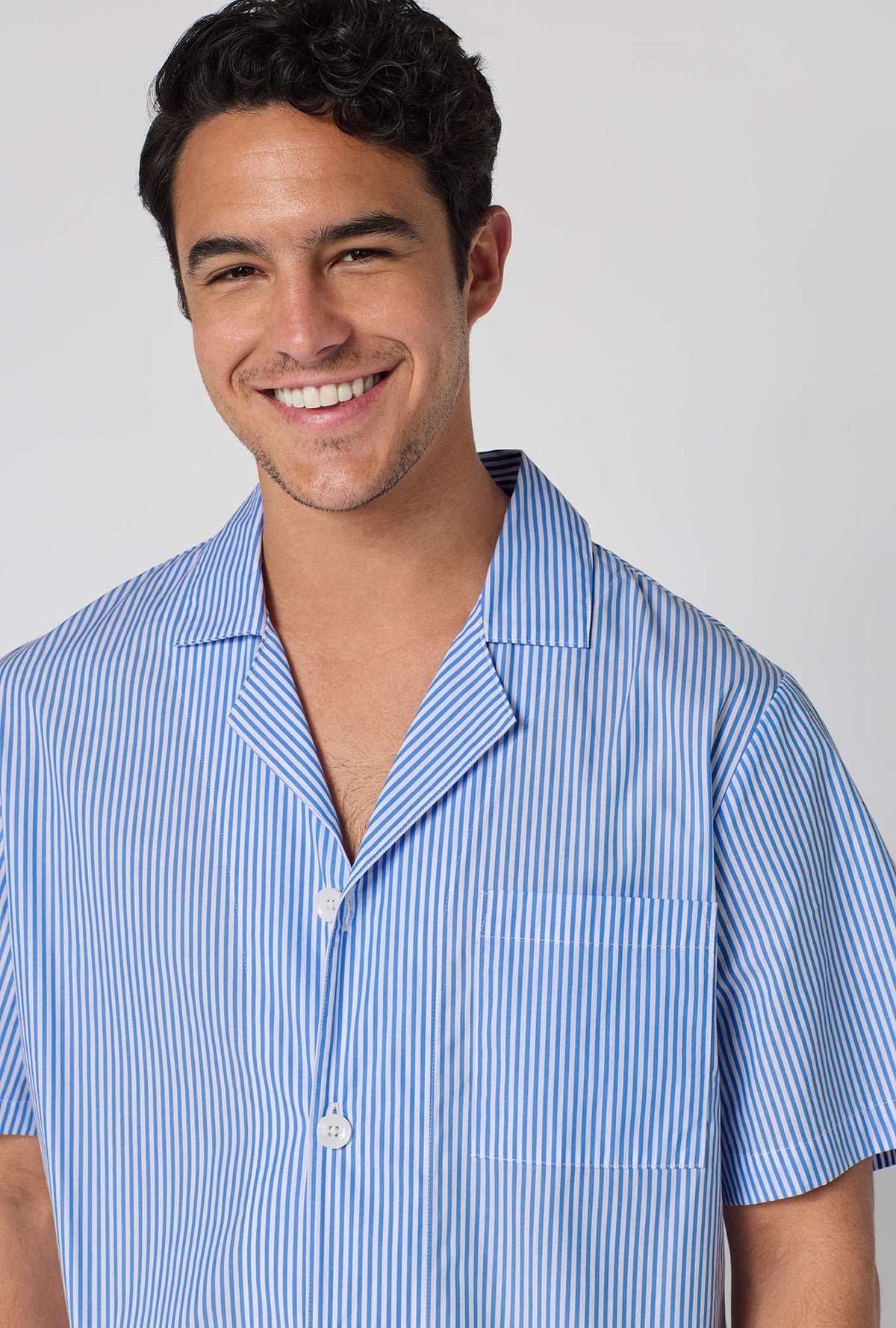 A Man Wearing French Stripe Men's Short Sleeve Woven Supersoft Cotton Poplin Short Pj Set in a close up smiling pose