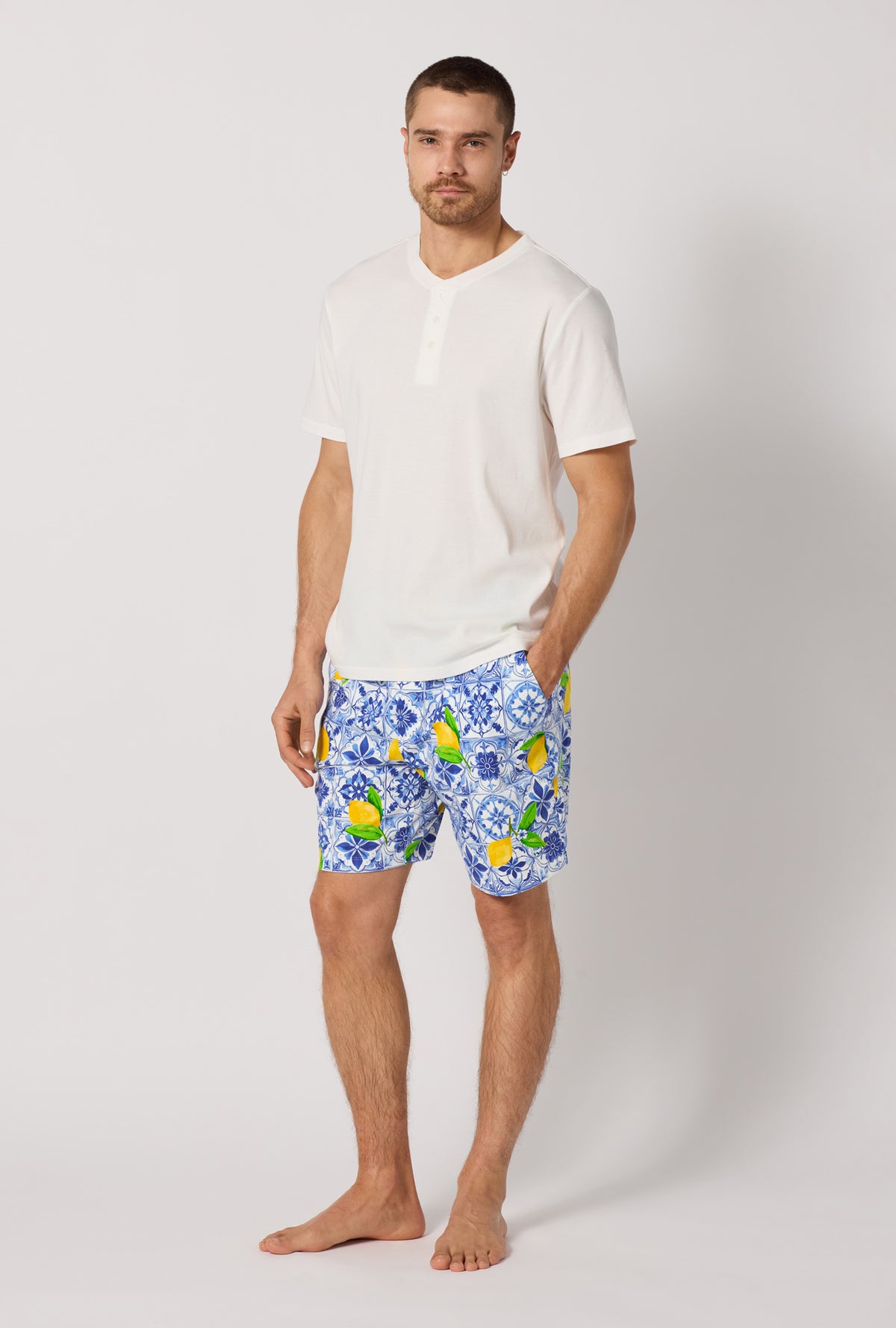 A man wearing Blue and  White Men's Short Sleeve Henley Stretch Jersey Short Pj Set side view