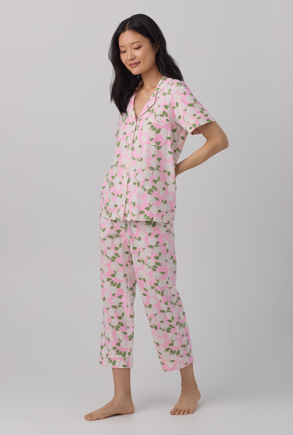 A lady wearing pink Hydrangea Short Sleeve Classic Stretch Jersey Cropped PJ Set with Pink Summer print.