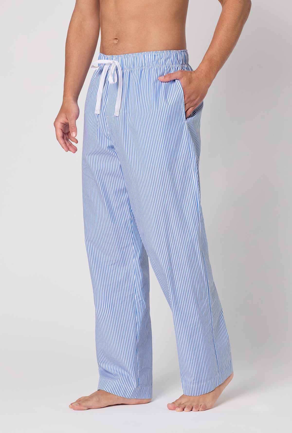 A Man Wearing French Stripe Men's Woven Supersoft Cotton Poplin Pj Pant in a side angled pose with one hand placed inside a pocket