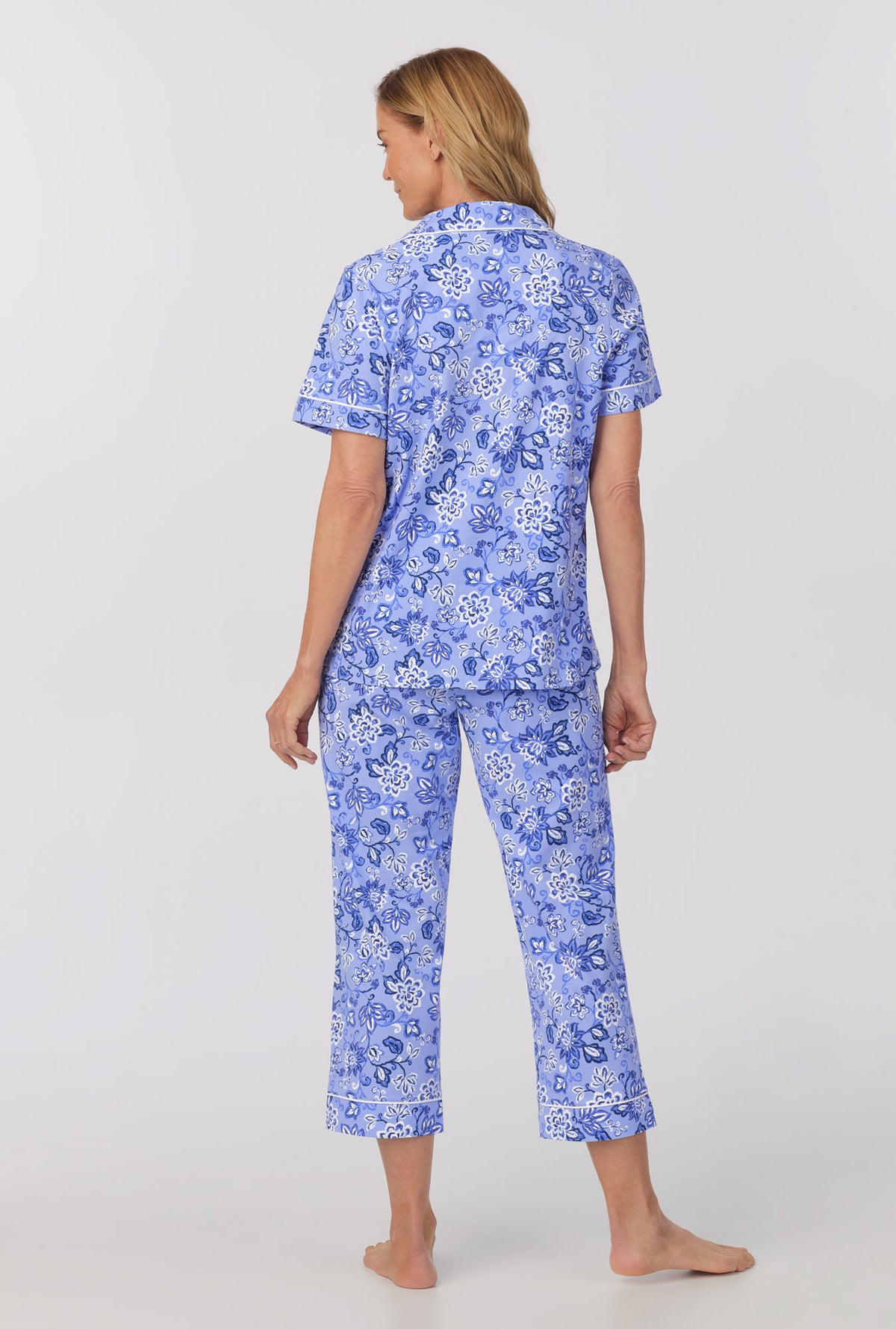 A lady wearing blue short sleeve classic stretch jersey cropped pj set with blue desert flowers print