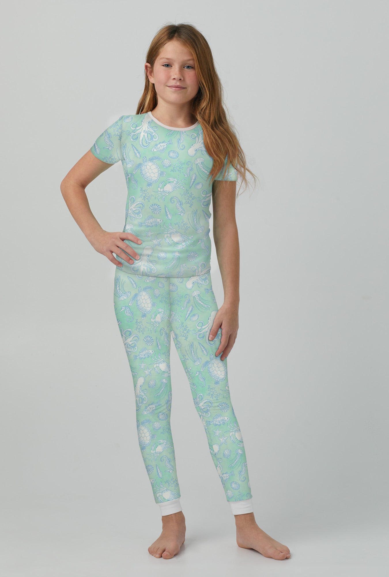 A girl wearing short sleeve stretch jersey pj set with aquatic life print