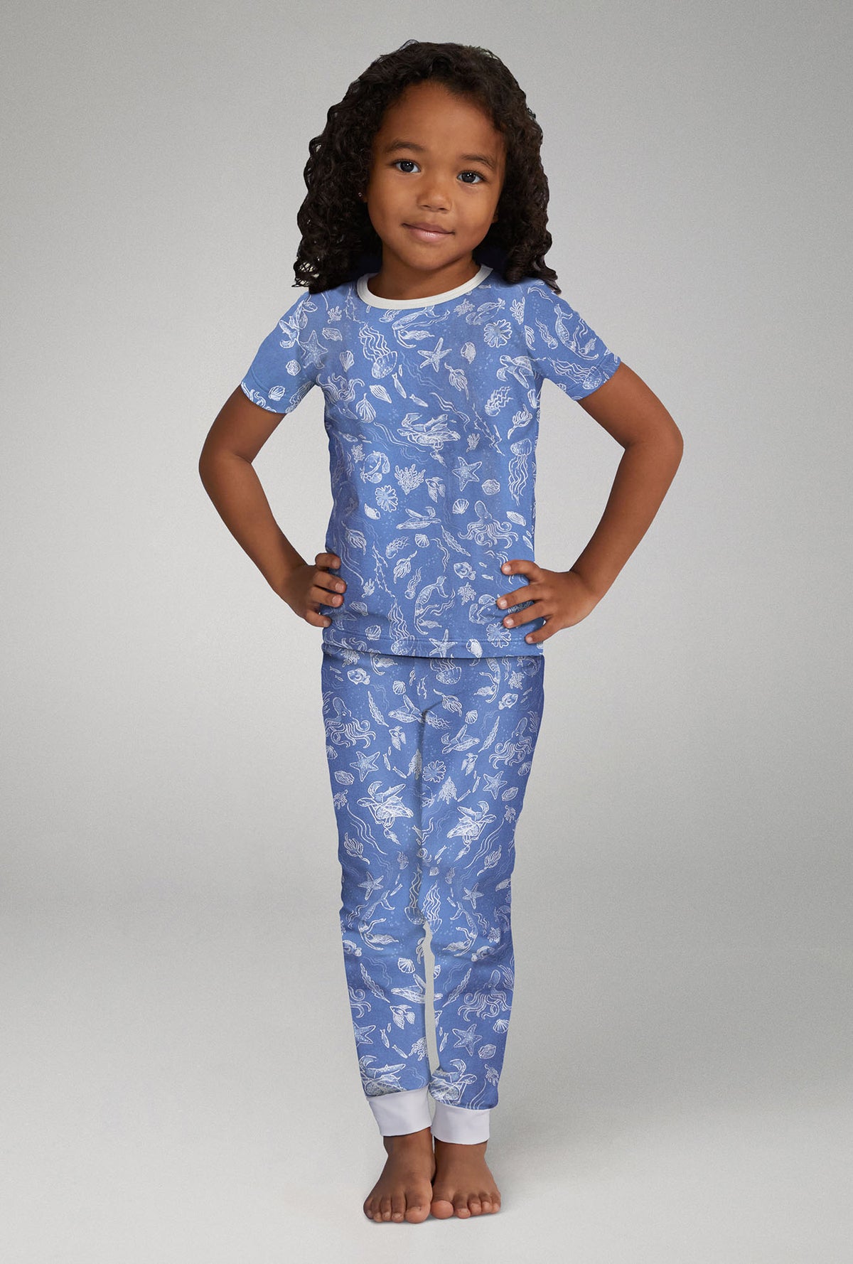 A girl wearing blue short sleeve stretch jersey pj set with high tide print.