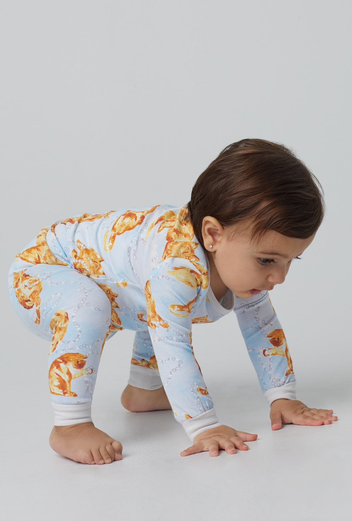 A baby wearing blue long sleeve stretch jersey boo boo pj set with fancy cats print.