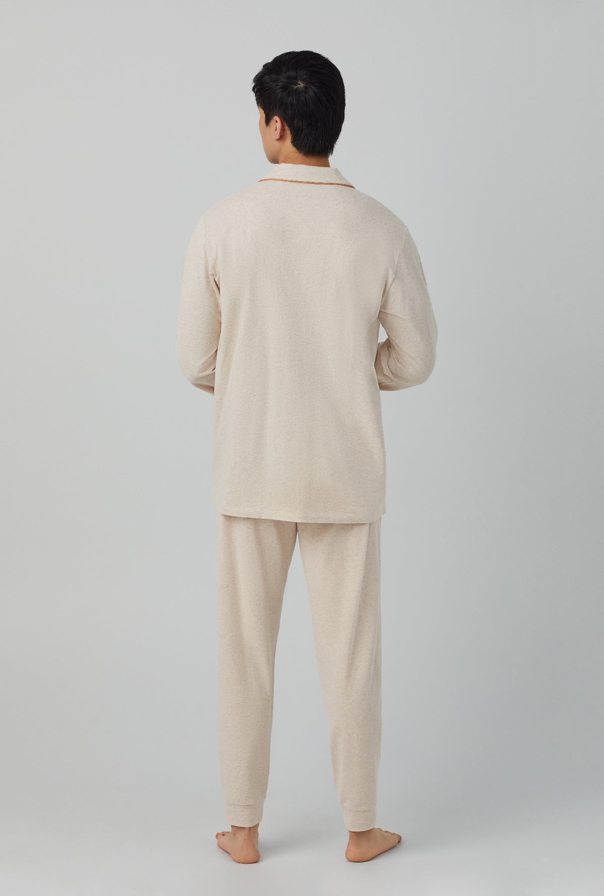 A man wearing henley and jogger stretch jersey pj set with latte heather print