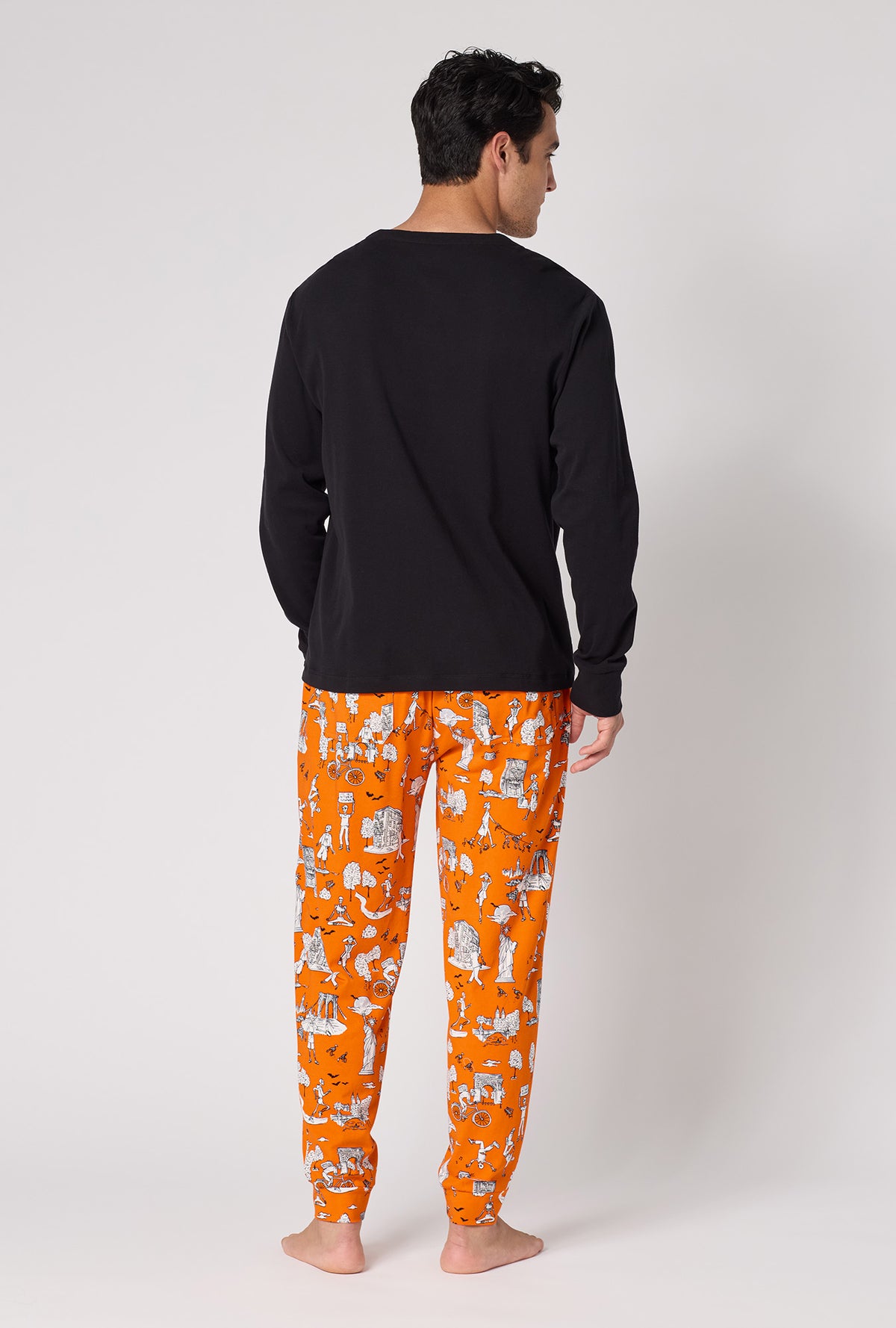 A Man Wearing Orange Spooky In The City Men's Long Sleeve Henley And Jogger Stretch Jersey Pj Set in a back view pose